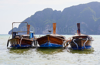 Buy stock photo Shot of a group of boats floating on the Andaman Sea