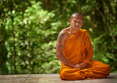Buy stock photo Portrait of a buddhist monk sitting outside with trees in the background