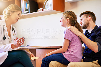 Buy stock photo Shot of a pediatrician consulting with a man and his young daughter in her office
