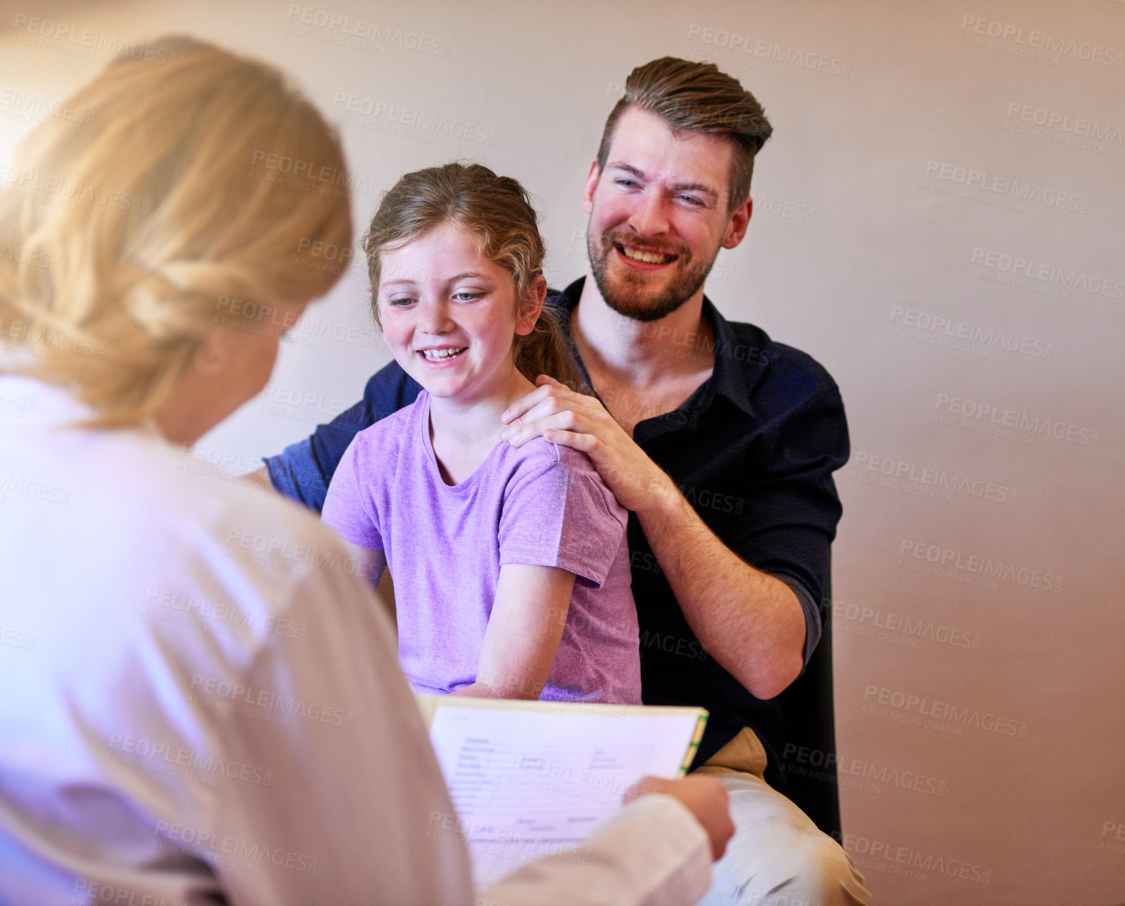 Buy stock photo Shot of a pediatrician consulting with a man and his young daughter in her office