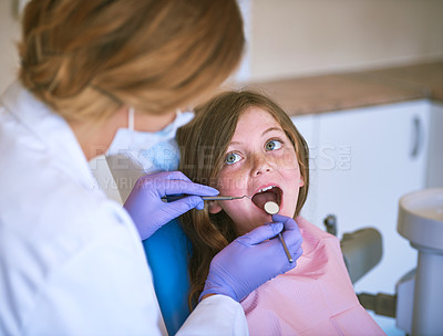 Buy stock photo Cropped shot of a dentist examining a little girl's teeth