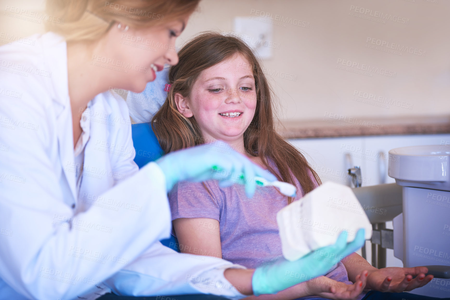 Buy stock photo Dentist, woman and teaching child for teeth, model and consulting for oral wellness in hospital. Girl, doctor and 3d mould with toothbrush, care or cleaning for health, hygiene and learning at clinic