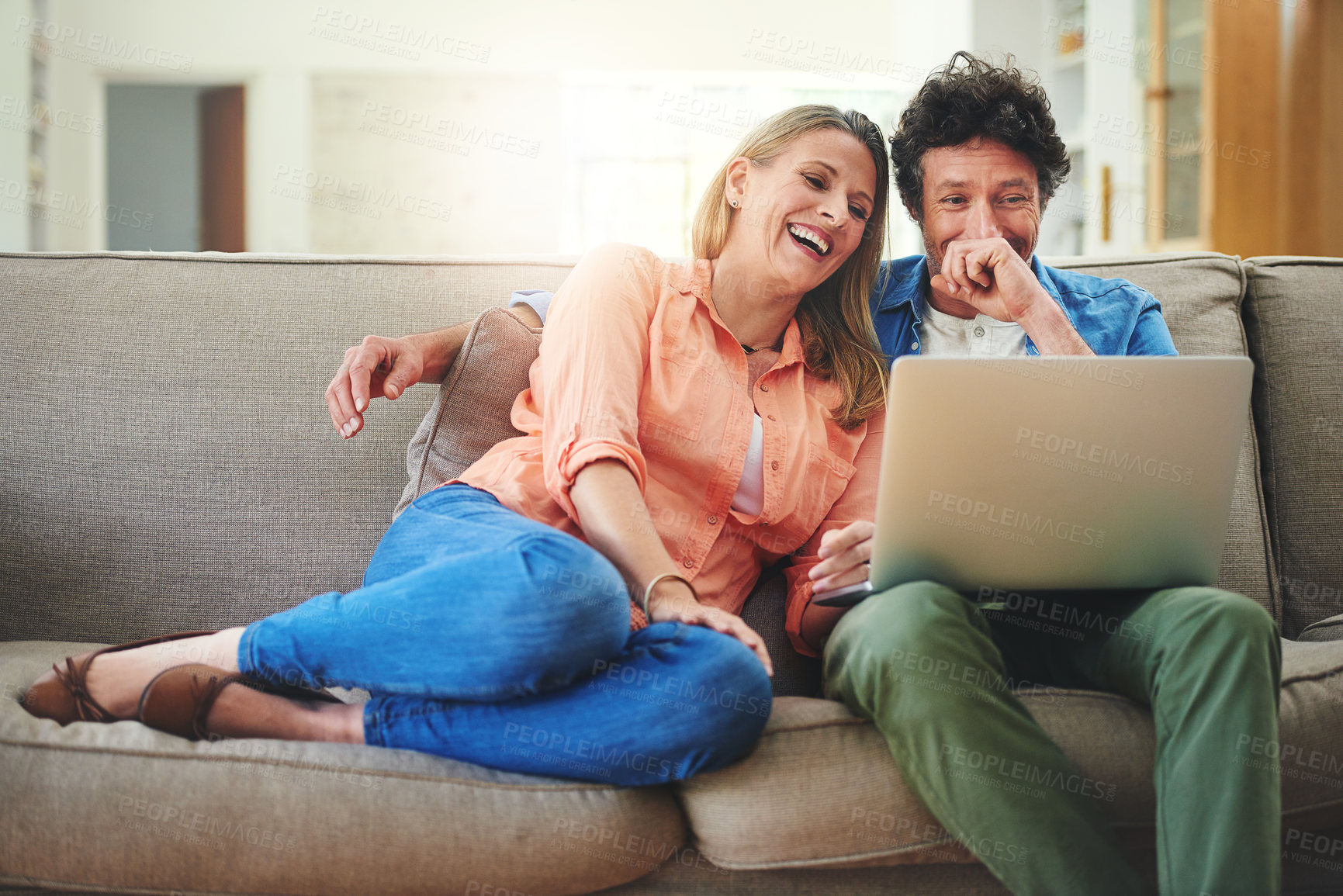 Buy stock photo Mature, couple and laughing with laptop on couch for comedy movie, funny series or streaming service in home. People, technology and comic video on sofa with relax, bonding or entertainment in lounge