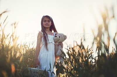 Buy stock photo Girl child, portrait or teddy bear in field with suitcase for travel game, journey with childhood friend for fun. Female kid, bag or toy in countryside for wellness trip with pride, assertive or calm