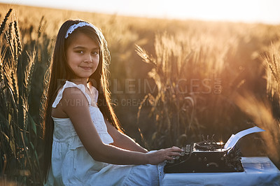 Buy stock photo Girl child, portrait or typewriter in nature for vintage play or dream career, writer or editor with antique. Female kid, typing or retro machine for future job with happiness in outdoor, fun or game