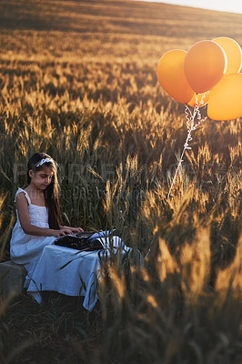 Buy stock photo Girl child, holiday or typewriter in nature for vintage play or dream career, writer or editor with antique. Female kid, typing or retro machine for future job with happiness in outdoor, fun or game