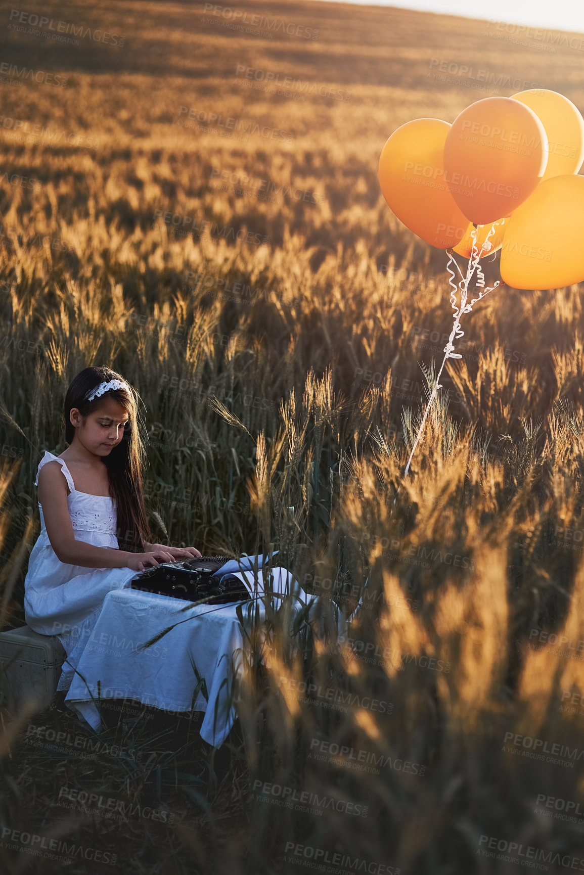 Buy stock photo Girl child, holiday or typewriter in nature for vintage play or dream career, writer or editor with antique. Female kid, typing or retro machine for future job with happiness in outdoor, fun or game