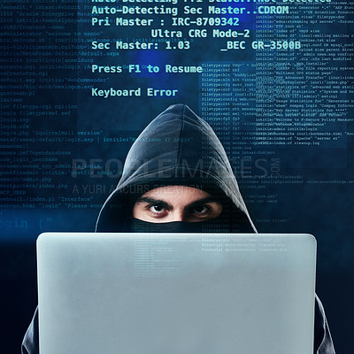Buy stock photo Portrait of a computer hacker using a laptop while standing against a dark background