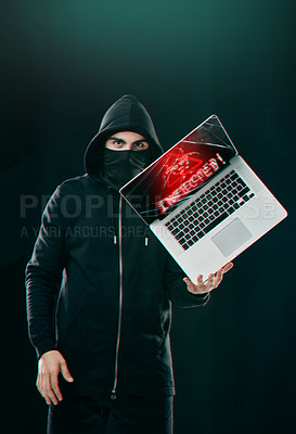 Buy stock photo Portrait of a computer hacker balancing a laptop while standing against a dark background
