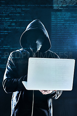 Buy stock photo Shot of an unidentifiable computer hacker using a laptop against a dark background