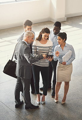 Buy stock photo High angle shot of a group of businesspeople talking together while standing in an office lobby