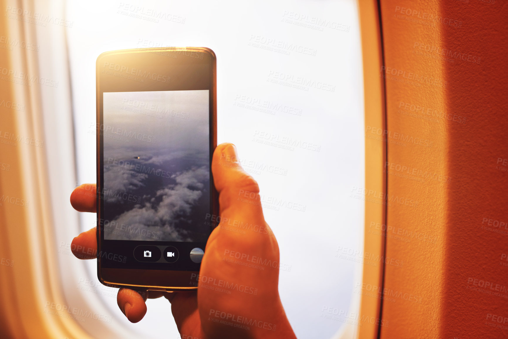 Buy stock photo Shot of a person taking a photo of the view through an airplane window