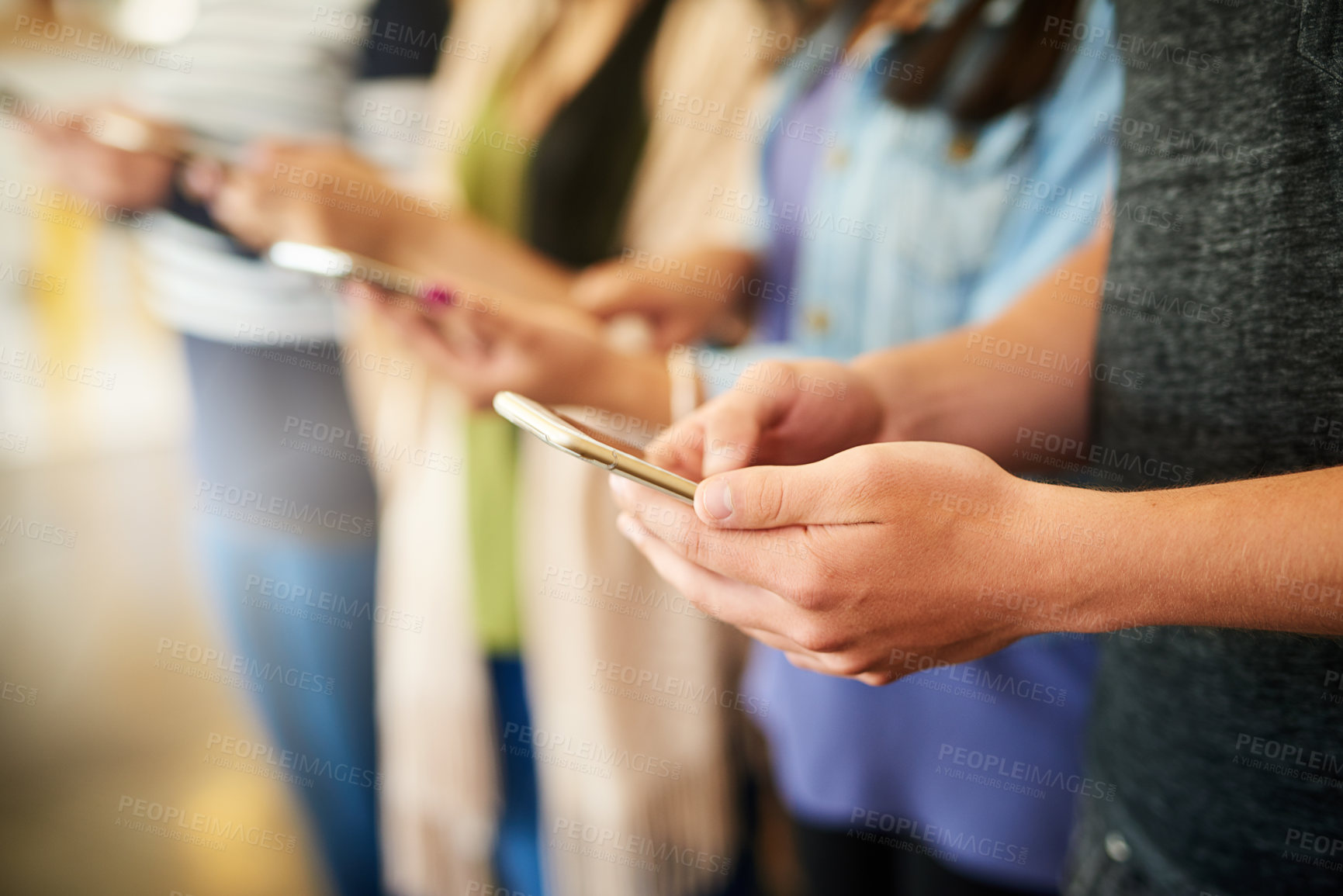 Buy stock photo Cropped shot of a group of unrecognisable people using their cellphones