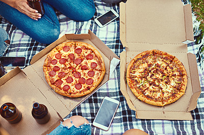 Buy stock photo Cropped shot of a group of friends eating pizza while having a picnic