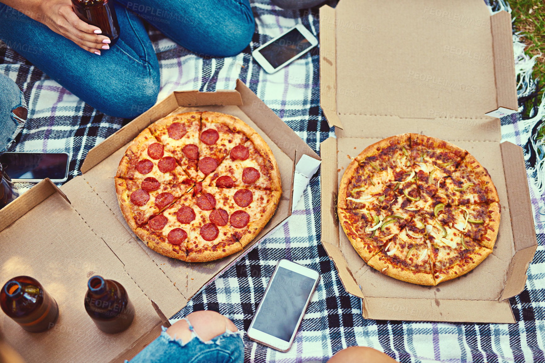 Buy stock photo Cropped shot of a group of friends eating pizza while having a picnic