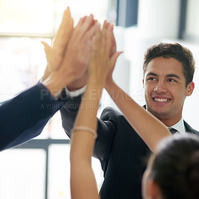 Buy stock photo Cropped shot of a group of businesspeople high fiving together in an office