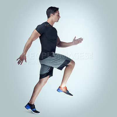 Buy stock photo Studio shot of an athletic young man running against a grey background