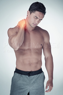 Buy stock photo Studio shot of an athletic young man suffering with neck pain against a grey background