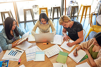 Buy stock photo High angle shot of a group of young students having a study session in a cafe