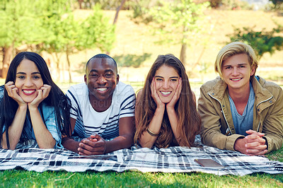 Buy stock photo Friends, group and portrait with blanket at park for solidarity with diversity, break and relax on grass field. Men, women and people at picnic, happy or bonding with connection on lawn at college