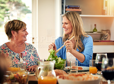 Buy stock photo Shot of a mature woman and her elderly mother enjoying a meal together at home