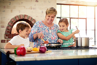 Buy stock photo Shot of a grandmother cooking with her two grandchildren at home