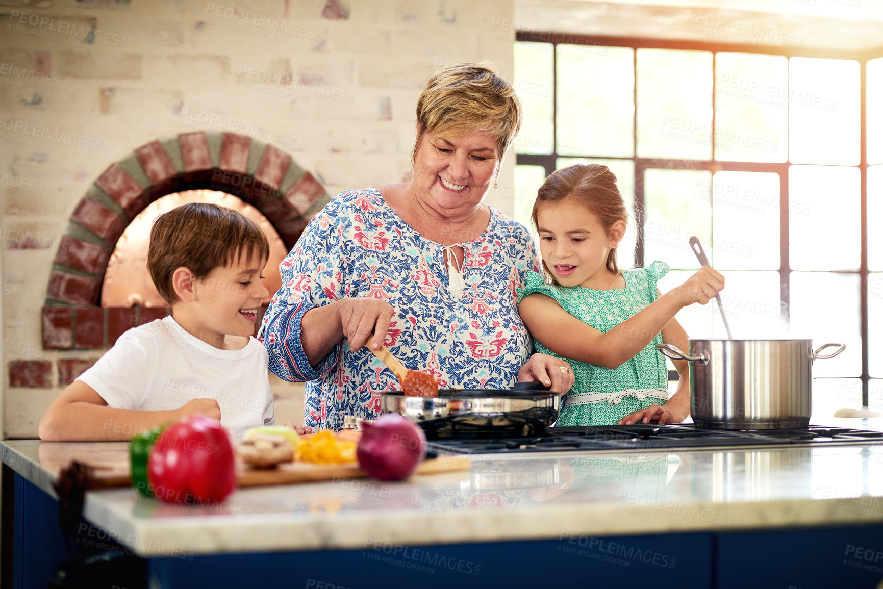 Buy stock photo Shot of a grandmother cooking with her two grandchildren at home