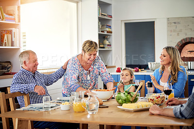 Buy stock photo Shot of a multi generational family enjoying a meal together at home