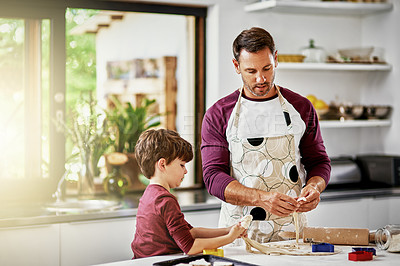 Buy stock photo Shot of a father and son baking biscuits in the kitchen