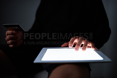 Buy stock photo Cropped shot of an unidentifiable hacker using a tablet late at night