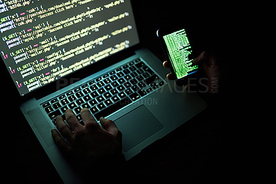 Buy stock photo Cropped shot of an unidentifiable hacker using a laptop late at night