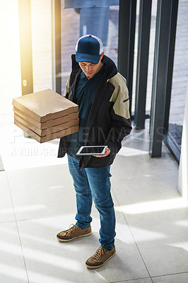Buy stock photo Shot of a young man making a pizza delivery in an office