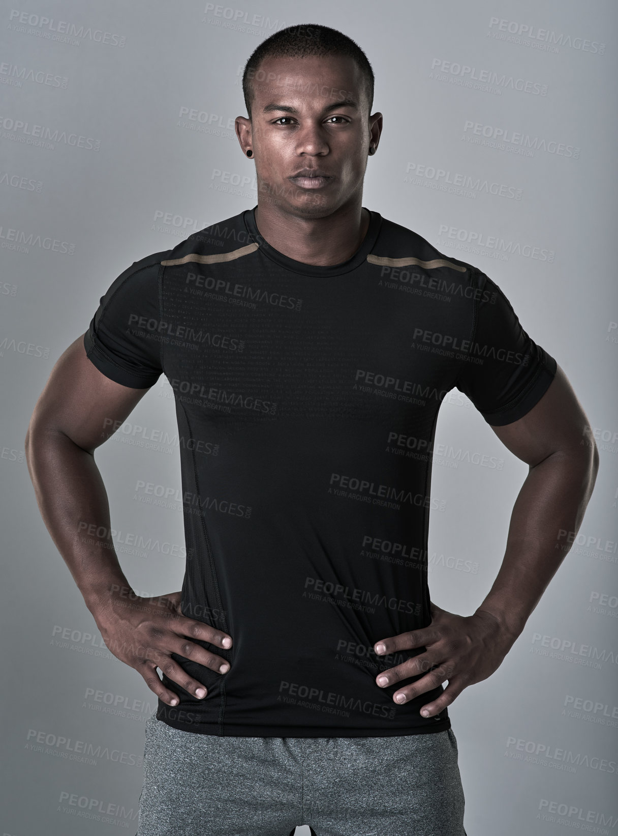 Buy stock photo Studio portrait of an athletic young man standing with his hands on his hips