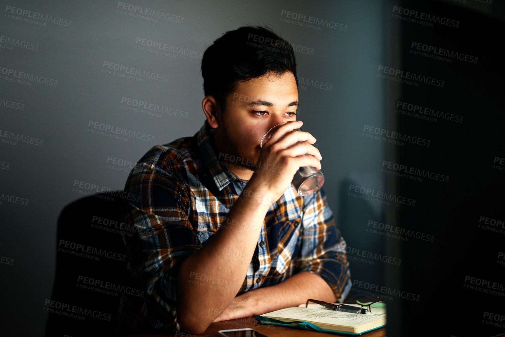 Buy stock photo Man, drinking water and night with computer for deadline, design or project at office. Tired male person or designer working late with mineral liquid in stress for hydration, overworked or fatigue