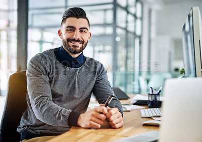 Buy stock photo Portrait of a confident young designer sitting at his desk in an office