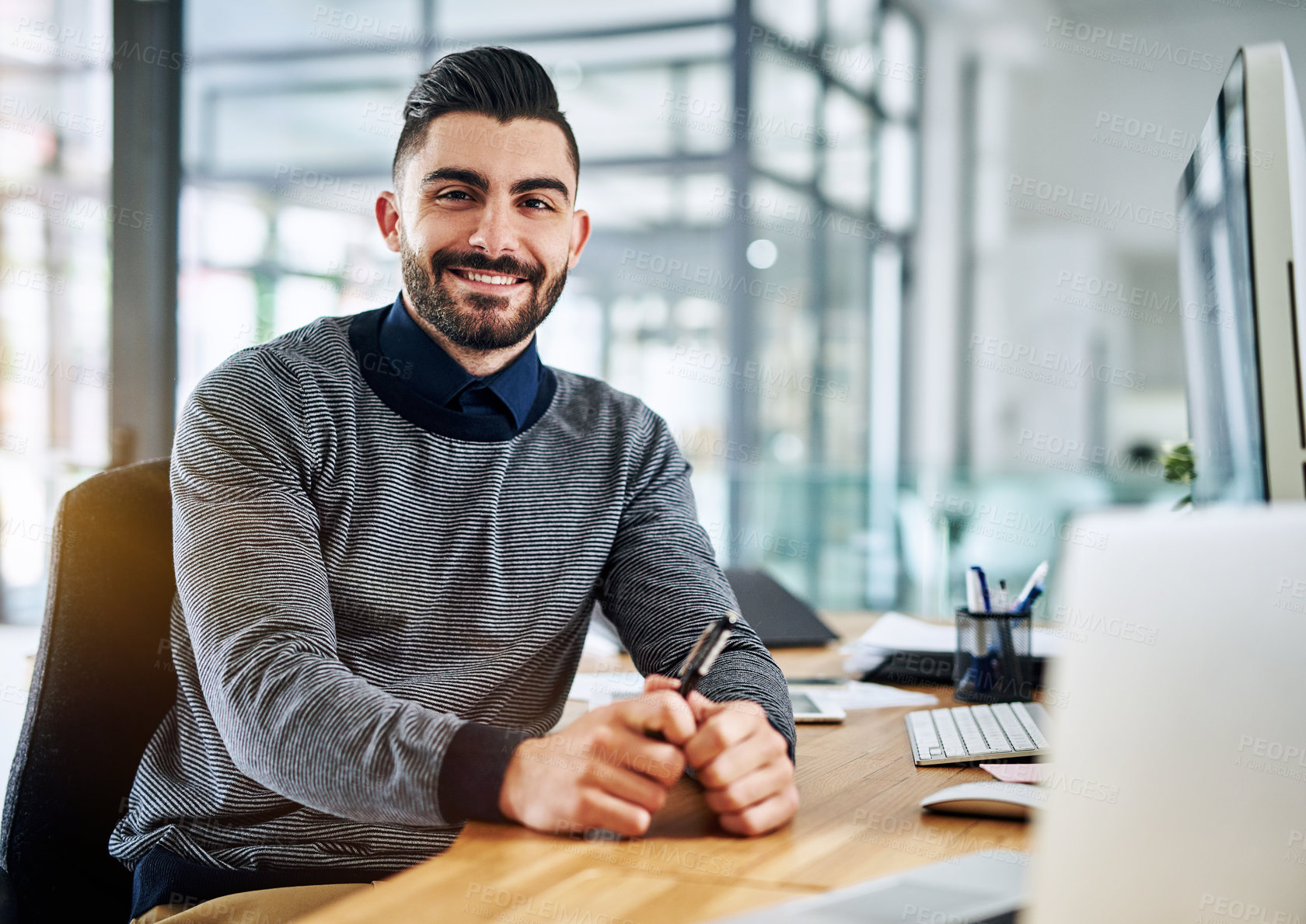 Buy stock photo Portrait of a confident young designer sitting at his desk in an office