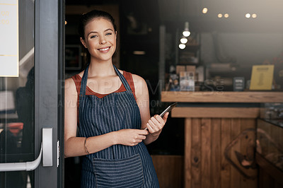 Buy stock photo Portrait of a confident young woman standing in the doorway of a coffee shop