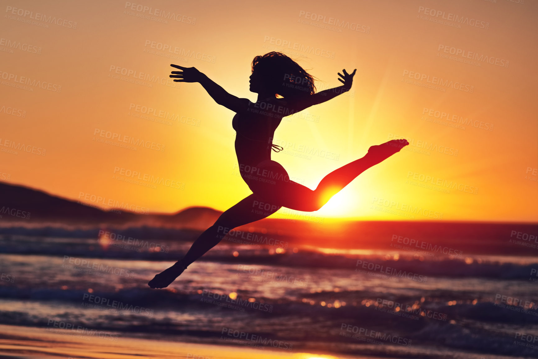 Buy stock photo Silhouette of an energetic woman jumping on the beach at sunset