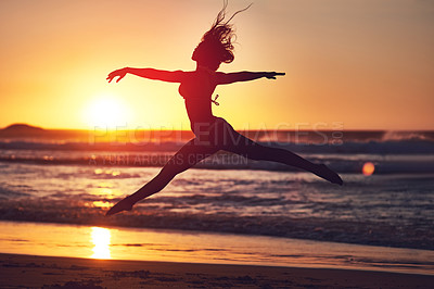 Buy stock photo Silhouette of an energetic woman jumping on the beach at sunset