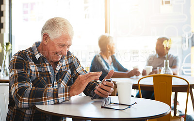 Buy stock photo Shot of a senior man using his phone in a cafe