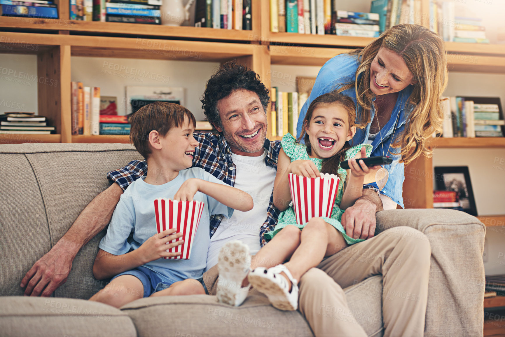 Buy stock photo Happy family, relax and laughing with popcorn for comedy movie, weekend or holiday on living room sofa at home. Mom, dad and young children with smile for funny show or streaming service at house