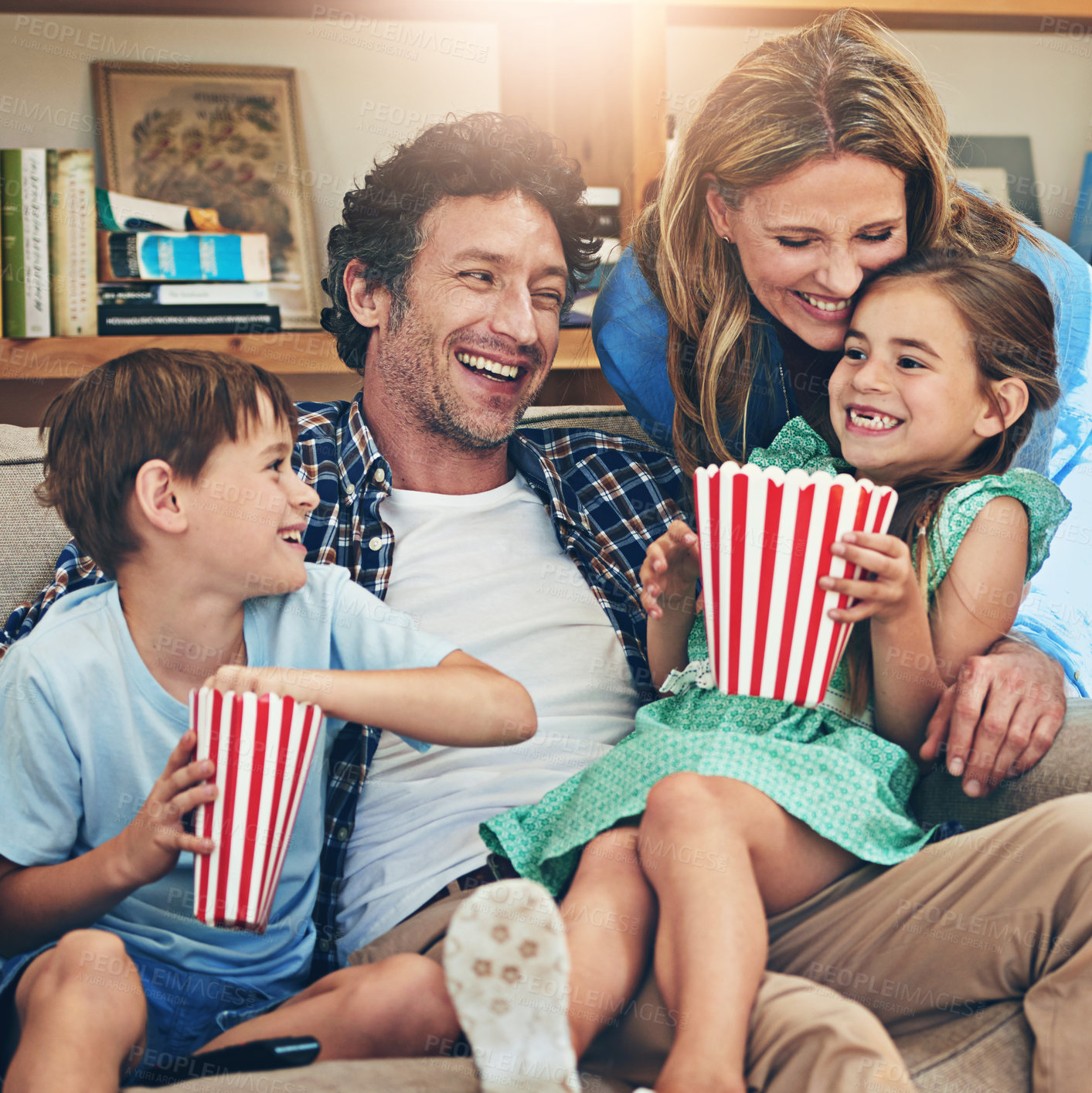 Buy stock photo Happy family, relax and laughing with popcorn on sofa for funny movie, weekend or holiday in living room at home. Mom, dad and children with smile for comedy, series or streaming service at house