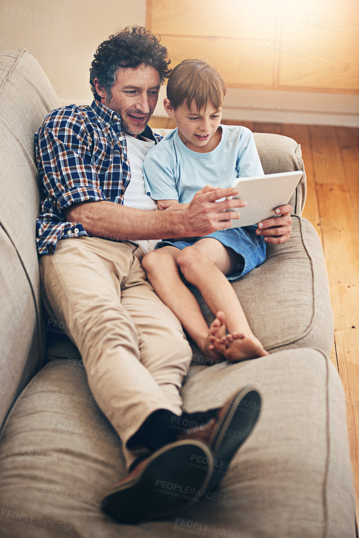 Buy stock photo Relax, tablet and father with child on sofa in home for watching movies, cartoons and online entertainment. Family, love and dad with son on digital tech for internet, video call and relax on weekend