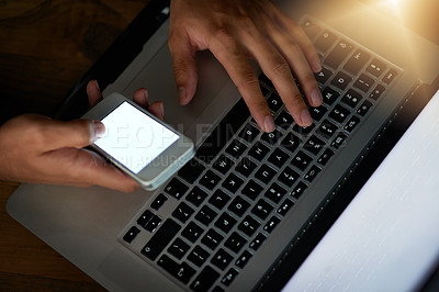 Buy stock photo High angle shot of a hacker using a cellphone to cracking a computer code in the dark