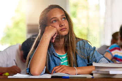 Buy stock photo Shot of a distracted young schoolgirl daydreaming in class