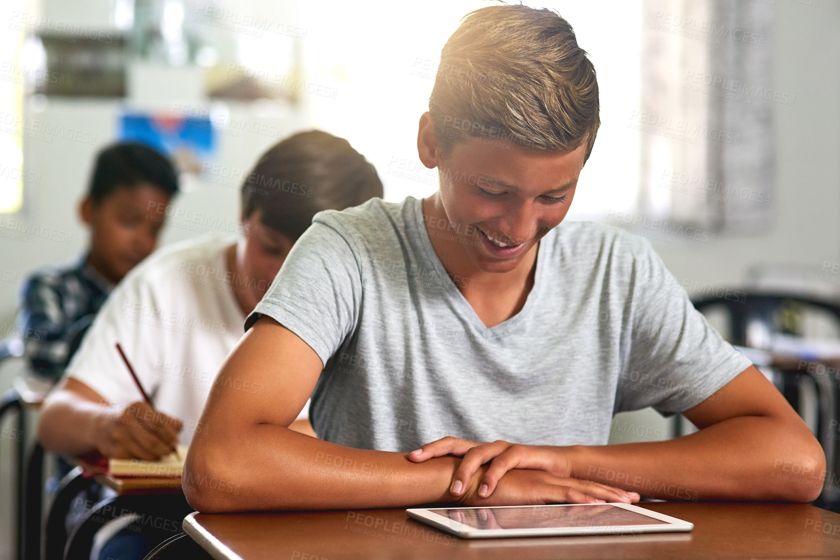 Buy stock photo Student, boy and happy with tablet in classroom at school for education, knowledge and lesson for child development. Elearning, smile and excited as kid with games or videos for teaching and learning