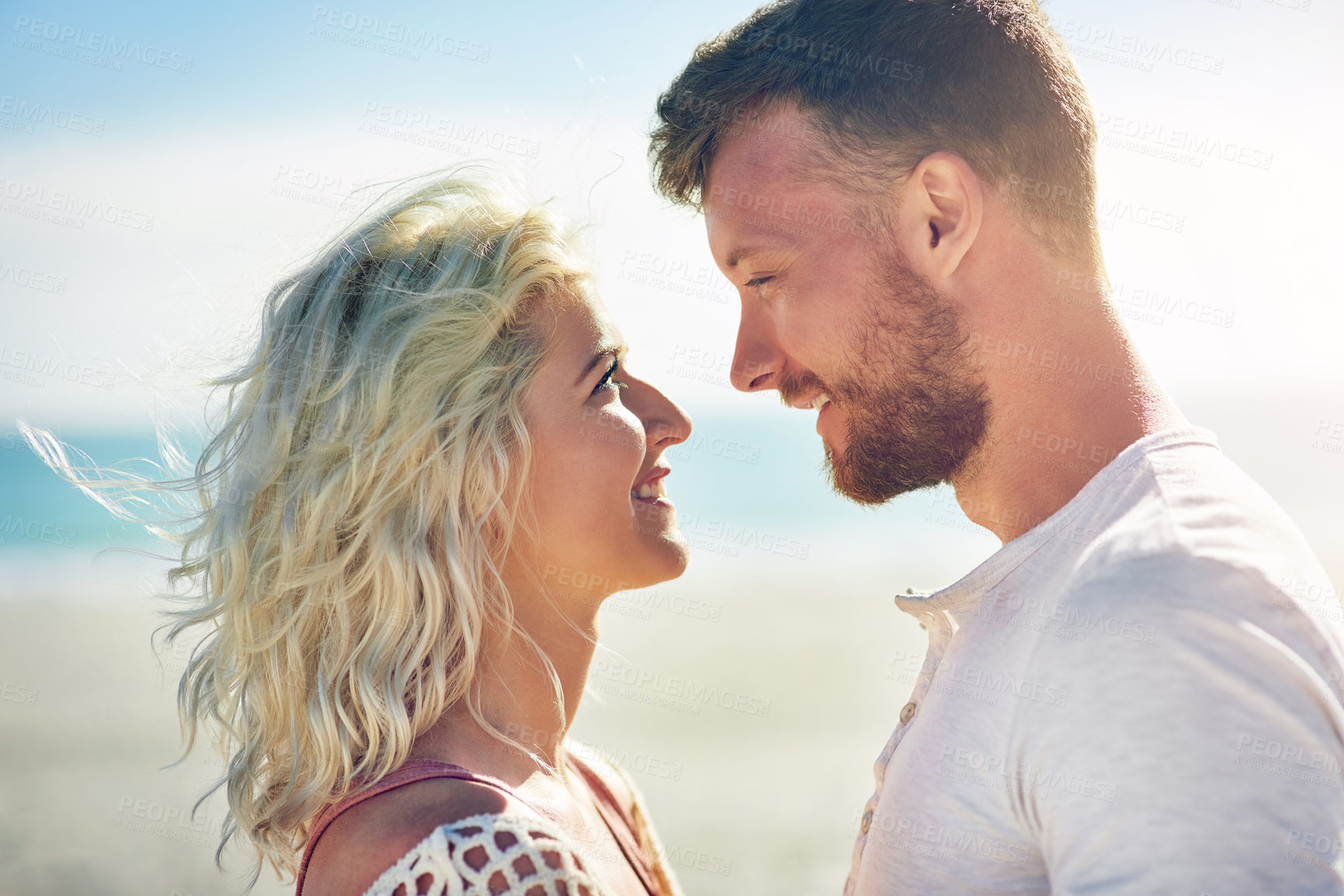 Buy stock photo Happy, couple and sunshine on beach with love for seaside romance, serene holiday and ocean with affection. Man, woman and together for bonding by coast on weekend date, embrace and trip with care