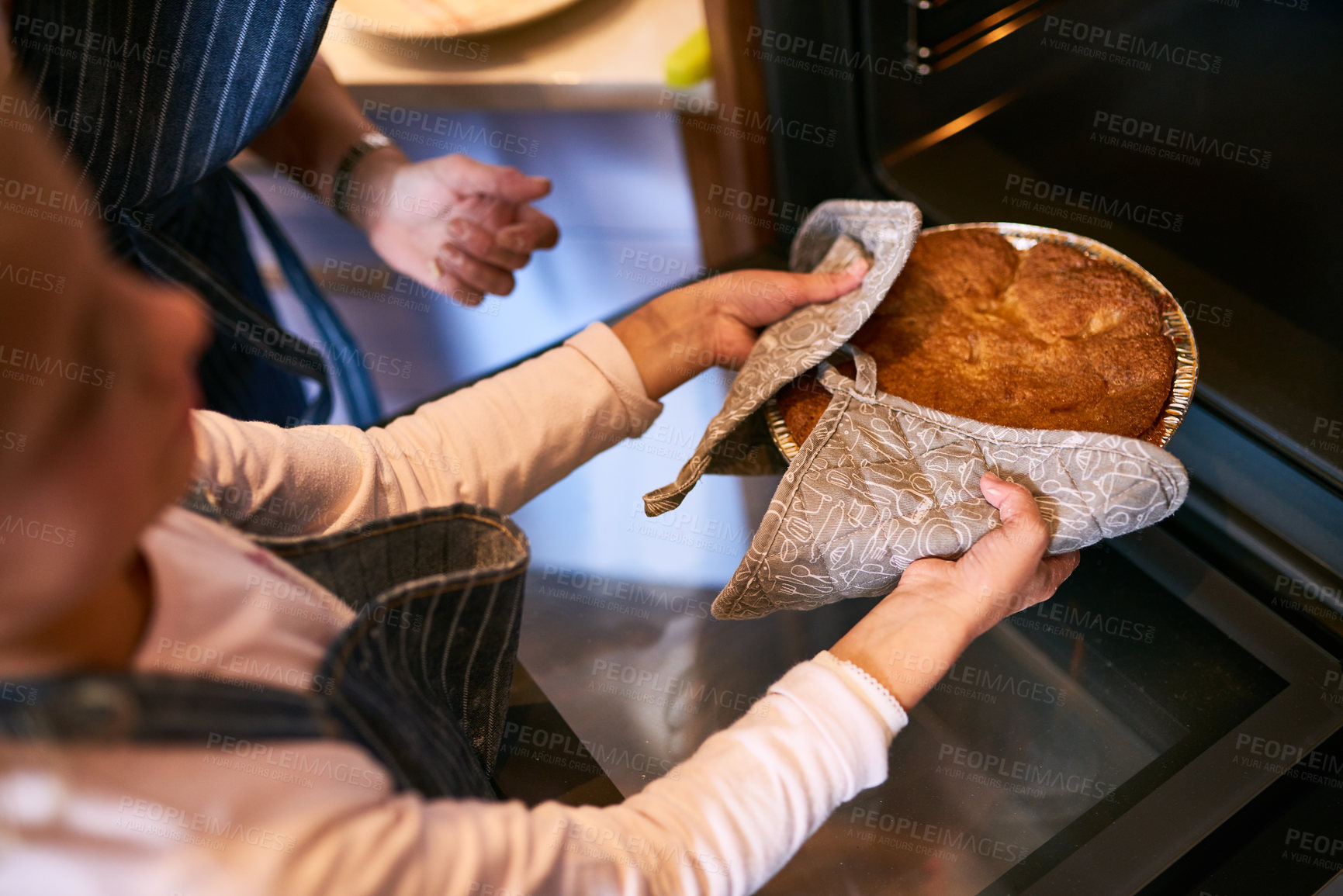 Buy stock photo Cropped shot of a little girl removing a freshly baked cake from the oven at home