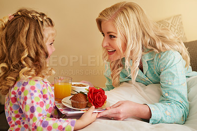 Buy stock photo Cropped shot of a little girl serving breakfast in bed to her mother at home