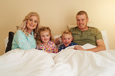 Buy stock photo Portrait of a happy family relaxing in bed together at home